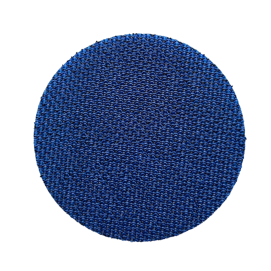Klettauflage_60mm_selbstklebend_freigestellt Close-up of a circular blue textured surface filling the lower half of the frame, showing a dense repeating woven-like pattern with small raised bumps and subtle glossy highlights on a white background.