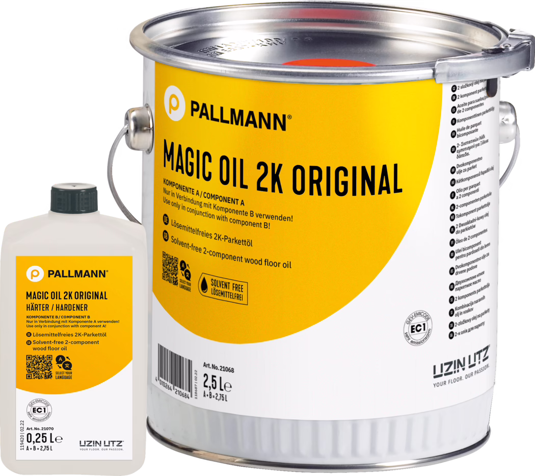 Close-up of a yellow-labeled metal can of PALLMANN Magic Oil 2K Original wood floor oil (2.5 L) with a small white hardener bottle (0.25 L) beside it; the label shows the brand logo, product name, usage instructions and a solvent-free icon; metal handle and sealed lid are visible; studio product photo on a white background.